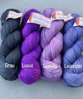 Vier Stränge Herzfasern No. 11 in Violett- und Grautönen: dunkles Grau, kräftiges Violett (Luxus), helles Lila (Tageslila) und kühles Lavendel – zusammengestellt als Set für den Westknits MKAL 2025.