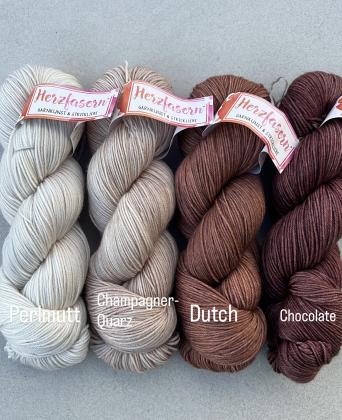 Vier Stränge Herzfasern No. 11 in neutralen, eleganten Naturtönen: helles Grau-Weiß (Perlmutt), warmes Beige (Champagner-Quarz), sattes Mittelbraun (Dutch) und dunkles Schokoladenbraun (Chocolate) – zusammengestellt als Set für den Westknits MKAL 2025.