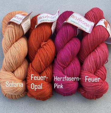 Vier Stränge Herzfasern No. 11 in intensiven Feuerfarben: warmes Apricot-Orange (Solana), leuchtendes Orange (Feuer-Opal), kräftiges Pink (Herzfasern Pink) und sattes Rot (Feuer) – zusammengestellt als Set für den Westknits MKAL 2025.