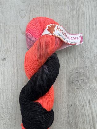 Ein handgefärbter Wollstrang in kräftigem Orange, das in tiefes Schwarz übergeht. Die Farben erinnern an Kürbisse, dunkle Nächte und Halloween.