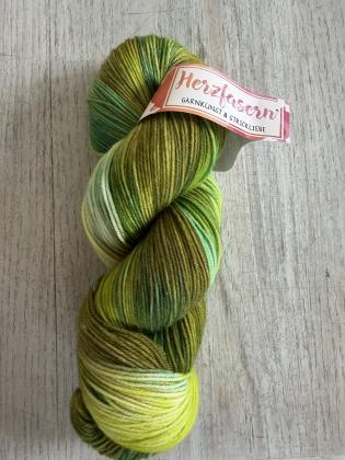 Handgefärbter Wollstrang in verschiedenen Grüntönen mit Nuancen von Limette, Salbei, Moosgrün und Oliv. Die natürliche Farbgebung erinnert an frische Kräuter, Gartenpflanzen und sommerliche Beete. Gefärbt auf Herzfasern No. 21.