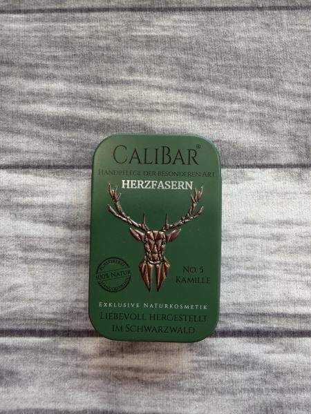 Grüne Metalldose mit Aufdruck „Calibar – Herzfasern – No. 5 Kamille“.