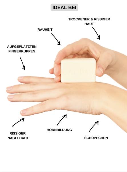 Eine Person trägt feste Handcreme auf die Hand auf. Die Creme wird direkt mit dem festen Stück auf die Haut gestrichen.
