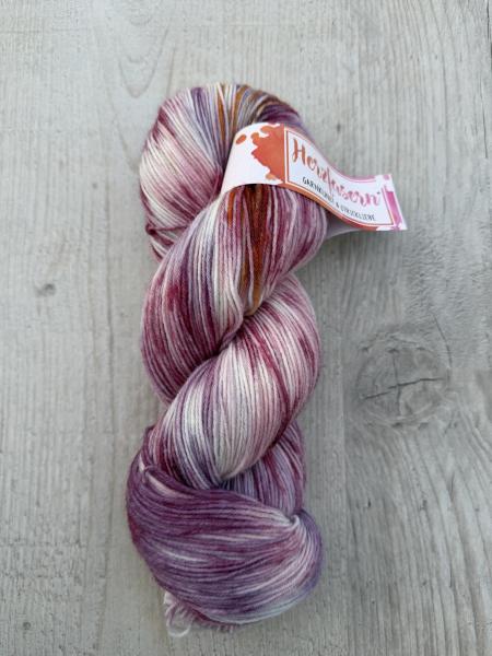 Mehrere handgefärbte Garnstränge der Marke Herzfasern liegen nebeneinander. Die Färbung „Loslassen“ zeigt sanfte, ruhige Farbtöne mit weichen Übergängen. Die Gesamtwirkung ist harmonisch und zurückhaltend.