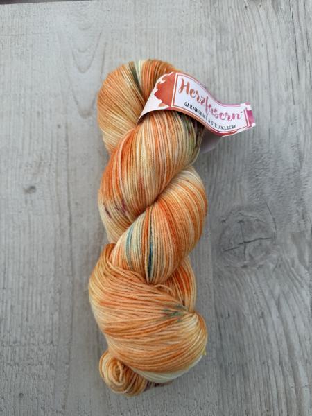 Mehrere handgefärbte Garnstränge der Marke Herzfasern liegen nebeneinander. Die Färbung „Transformation“ zeigt vielschichtige, ineinanderlaufende Farbtöne mit sichtbaren Übergängen. Die Gesamtwirkung ist lebendig, tief und im Wandel.